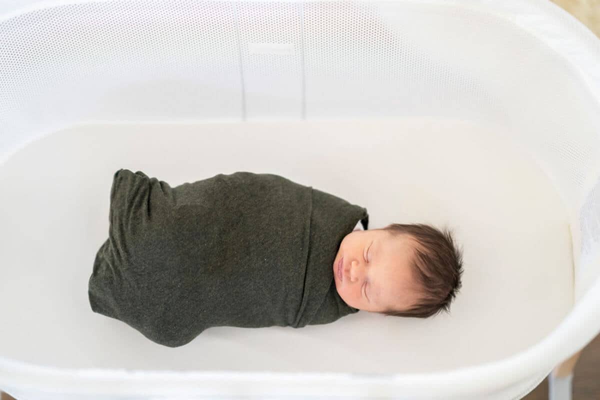 swaddled baby in bassinet